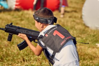 Игрок в жилете "Red Team" с автоматом LASERWAR.