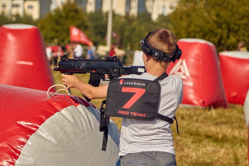 Мальчик в жилете "Red Team" с автоматом LASERWAR
