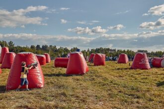 Мальчик в желтой футболке стреляет из бластера LASERWAR.