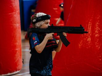 Девочка в шлеме LASERWAR с автоматом целится