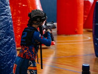 Боец LASERWAR прицеливается из оружия в игровой зоне
