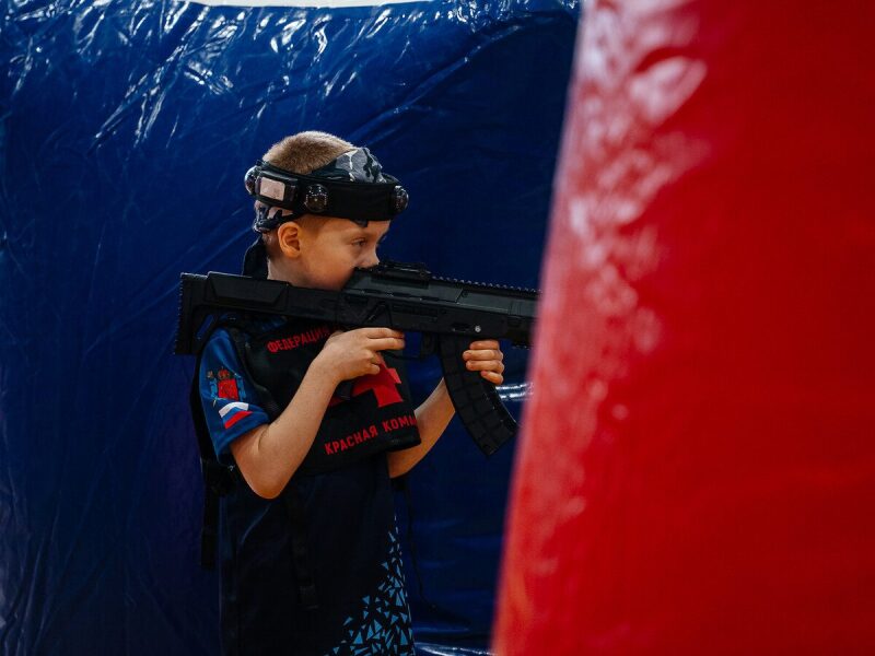 Мальчик в шлеме LASERWAR с автоматом наготове.