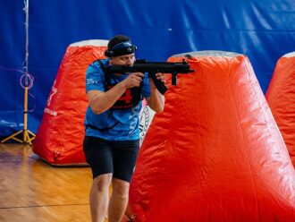 Боец LASERWAR в синей форме целится из оружия.