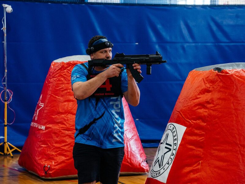 Боец «Красной команды» LASERWAR целится из оружия.