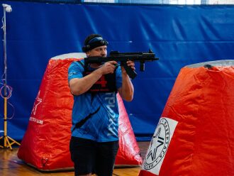 Боец «Красной команды» LASERWAR целится из оружия.