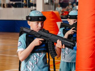 Юный боец LASERWAR в голубой форме держит оружие.