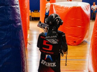 Боец «Красной команды» LASERWAR целится из оружия.