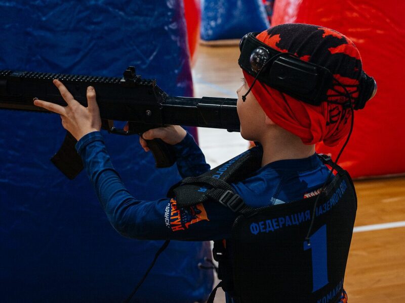 Юный игрок LASERWAR с автоматом в защитном снаряжении