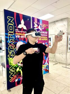Молодой человек в VR-шлеме управляет игрой