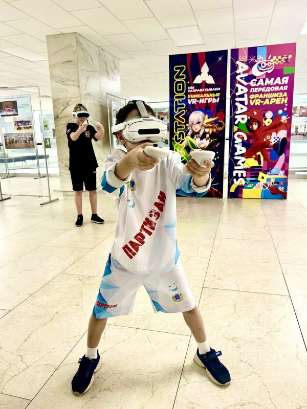 Юный игрок в VR-гарнитуре осваивает новые игровые технологии.