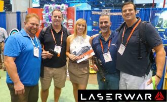 Группа людей с лазертаг-оружием LASERWAR позирует.