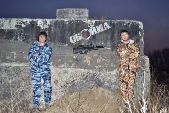Два бойца LASERWAR у бетонной стены с надписью