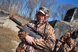 Боец LASERWAR в камуфляже с винтовкой готовится к бою