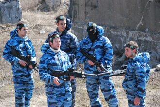 Лазертаг-отряд в синем камуфляже позирует с оружием.