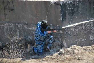 Боец LASERWAR в маске и камуфляже занял позицию.