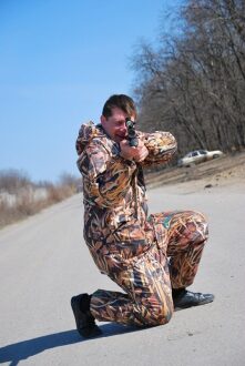 LASERWAR: боец в маскировочном костюме прицеливается.