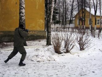 Лазертаг-боец LASERWAR в зимнем поле, прикрываясь деревом.