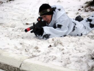 Снежная засада: боец LASERWAR в заснеженном укрытии.