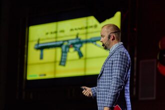 Спикер представляет новое оружие LASERWAR на экране.