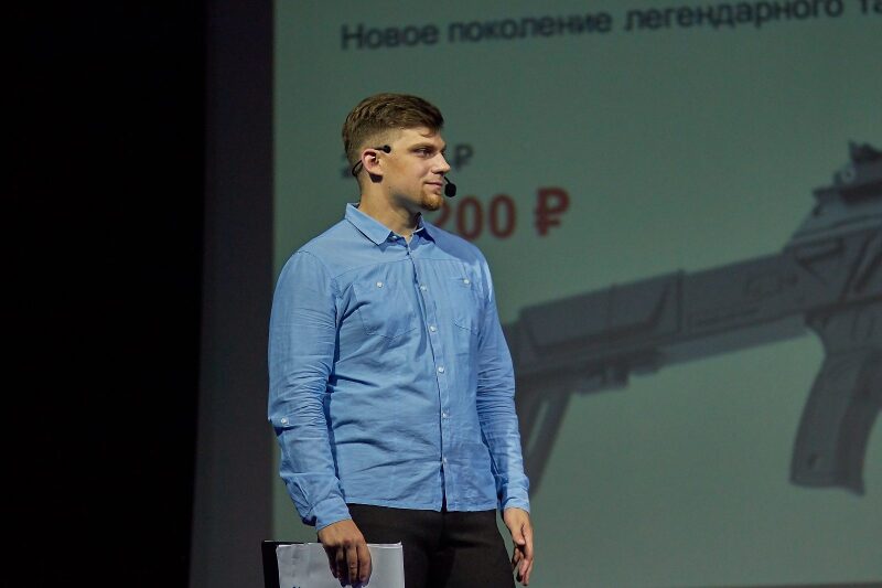 Мужчина в голубой рубашке на фоне презентации LASERWAR.
