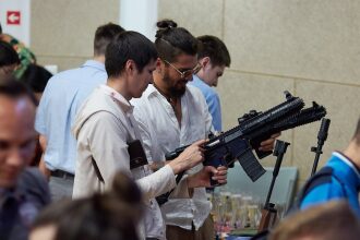Двое мужчин изучают лазертаг-винтовку LASERWAR
