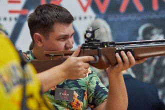 Мужчина целится из винтовки LASERWAR на мероприятии.