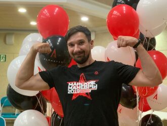 Мужчина демонстрирует силу на фоне воздушных шаров