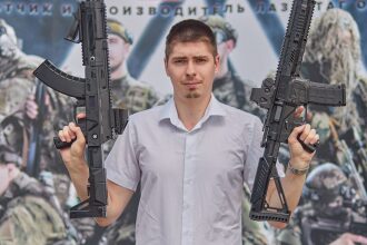 Мужчина в белой рубашке держит два лазертаг-автомата
