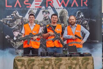 Три мужчины в оранжевых жилетах с оружием LASERWAR