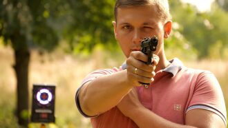 Мужчина с пистолетом LASERWAR наводит прицел