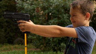 Мальчик с пистолетом LASERWAR готовится к выстрелу