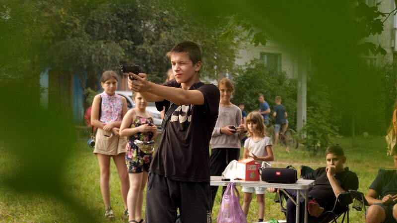 Парень с пистолетом LASERWAR на фоне группы