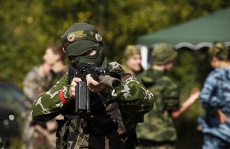 Боец LASERWAR в маске прицеливается из оружия.