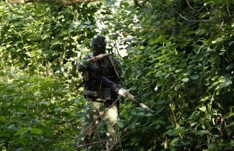 LASERWAR: боец в маскировке готов к бою в лесу.