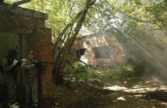 LASERWAR: два бойца у кирпичной стены, дым и лучи солнца.