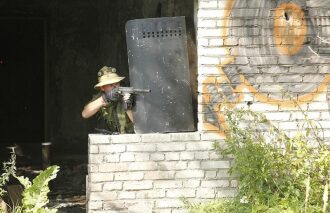 LASERWAR: Игрок с щитом и автоматом занимает позицию.