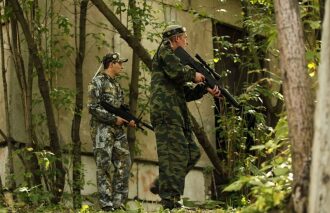 LASERWAR: два бойца в камуфляже с оружием у здания.