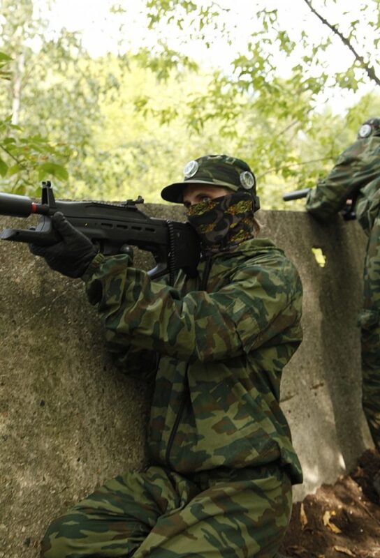 LASERWAR: боец в камуфляже целится из укрытия.