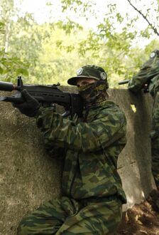 LASERWAR: боец в камуфляже целится из укрытия.
