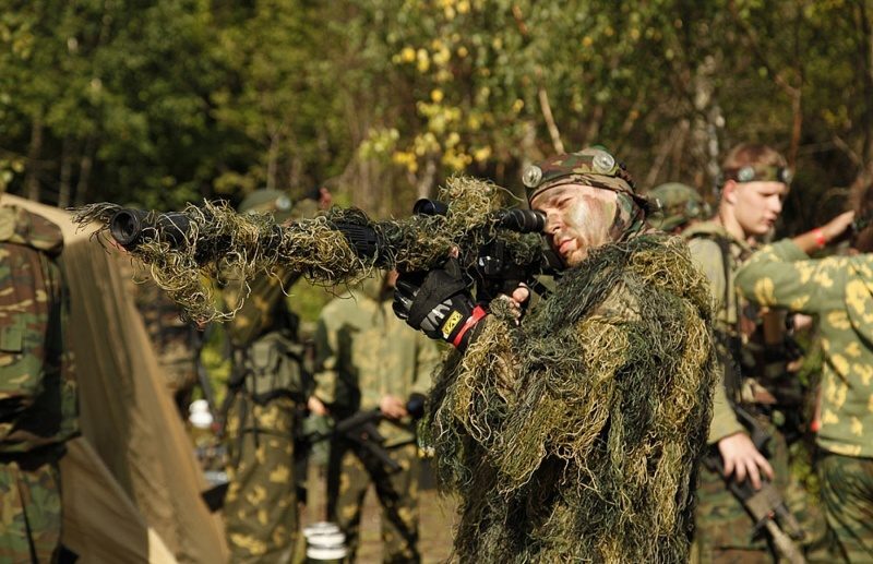 LASERWAR: снайпер в маскировке готов к выстрелу.