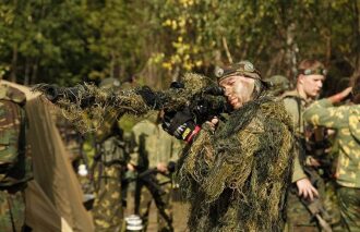 LASERWAR: снайпер в маскировке готов к выстрелу.