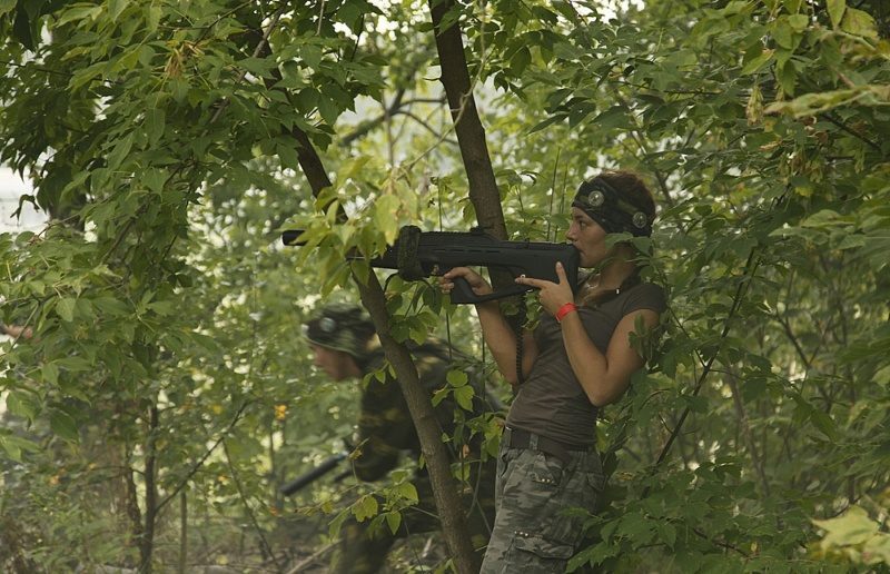 LASERWAR: девушка целится из-за густой листвы