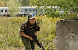 Девушка LASERWAR в засаде у бетонного укрытия.