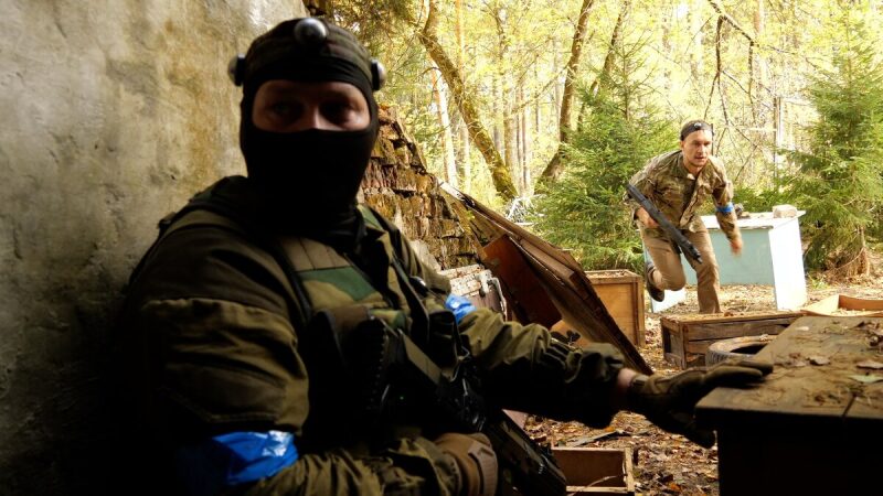 Боец LASERWAR в маске наблюдает за противником