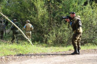 Боец LASERWAR ведет прицельный огонь из-за укрытия