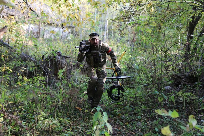 Боец LASERWAR с оборудованием спешит по лесной тропе