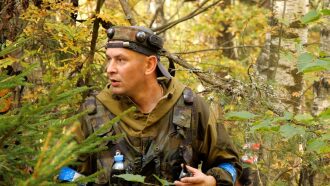 Игрок LASERWAR в камуфляже внимательно осматривает лес