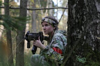 Девушка LASERWAR сосредоточена на игре в лесу