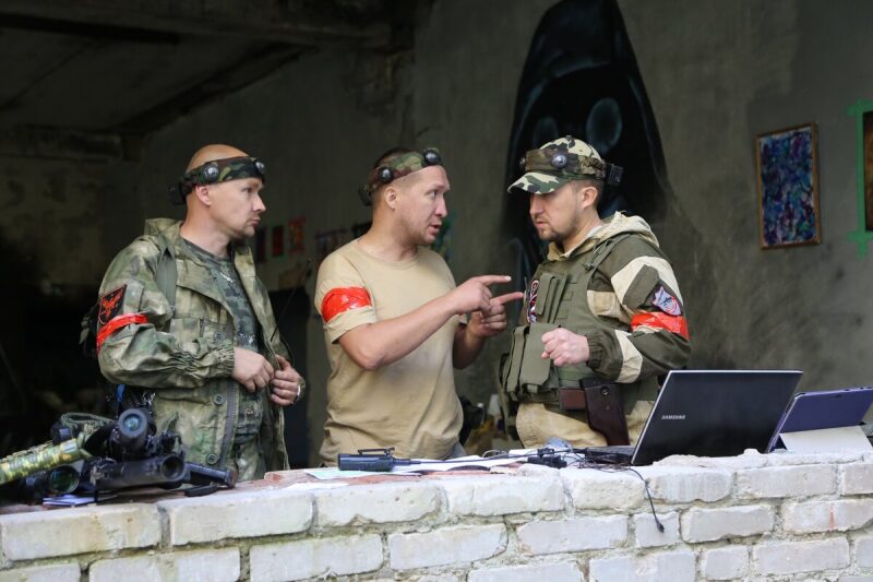 Игроки LASERWAR обсуждают тактику у ноутбука