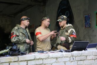 Игроки LASERWAR обсуждают тактику у ноутбука